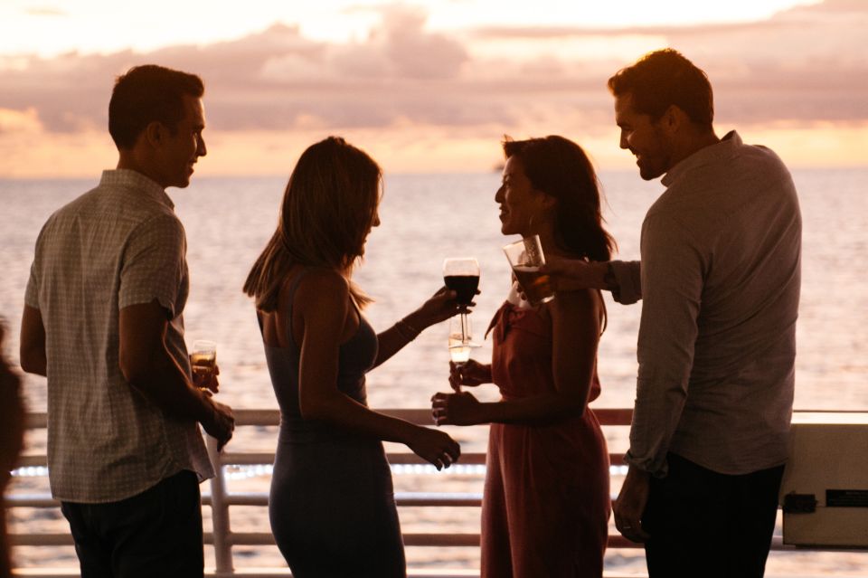 people having cocktails on boat deck at sunset