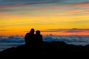 maui couple wathing sunrise on geach in maui